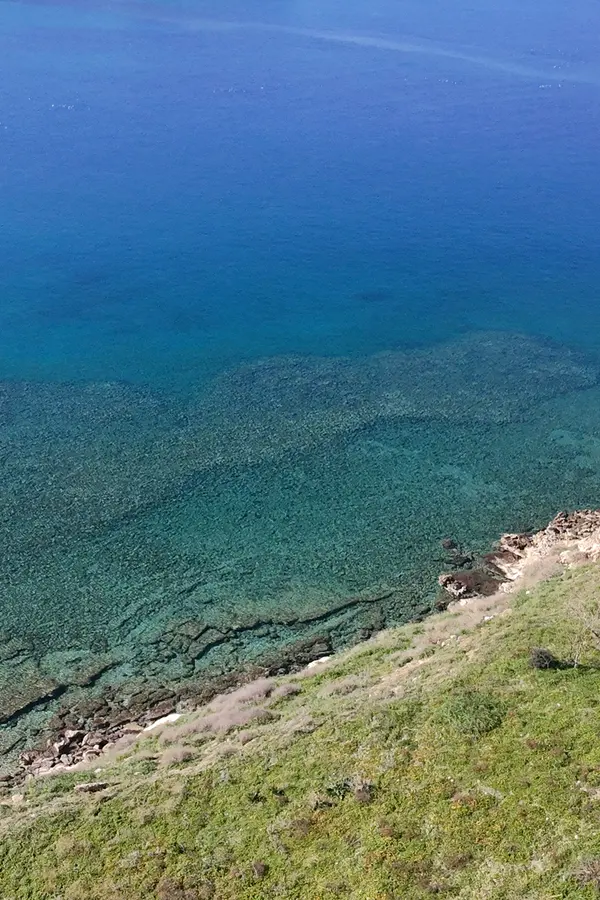 Coastal view capturing the traditional village architecture and deep blue waters of Karga Island.